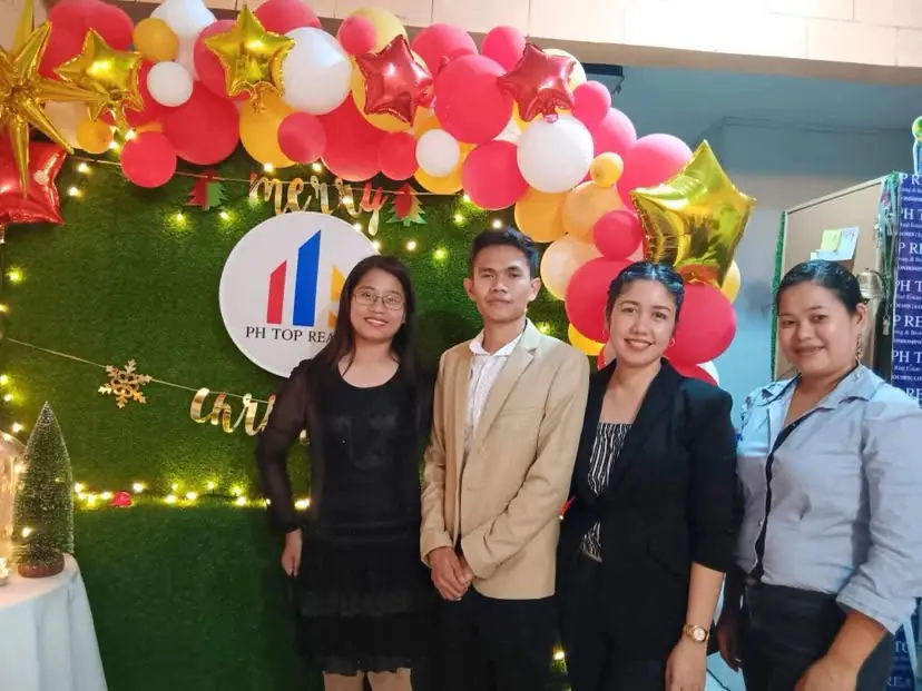 PH Top Realty leaders and guests pose in front of a branded corporate event backdrop.
